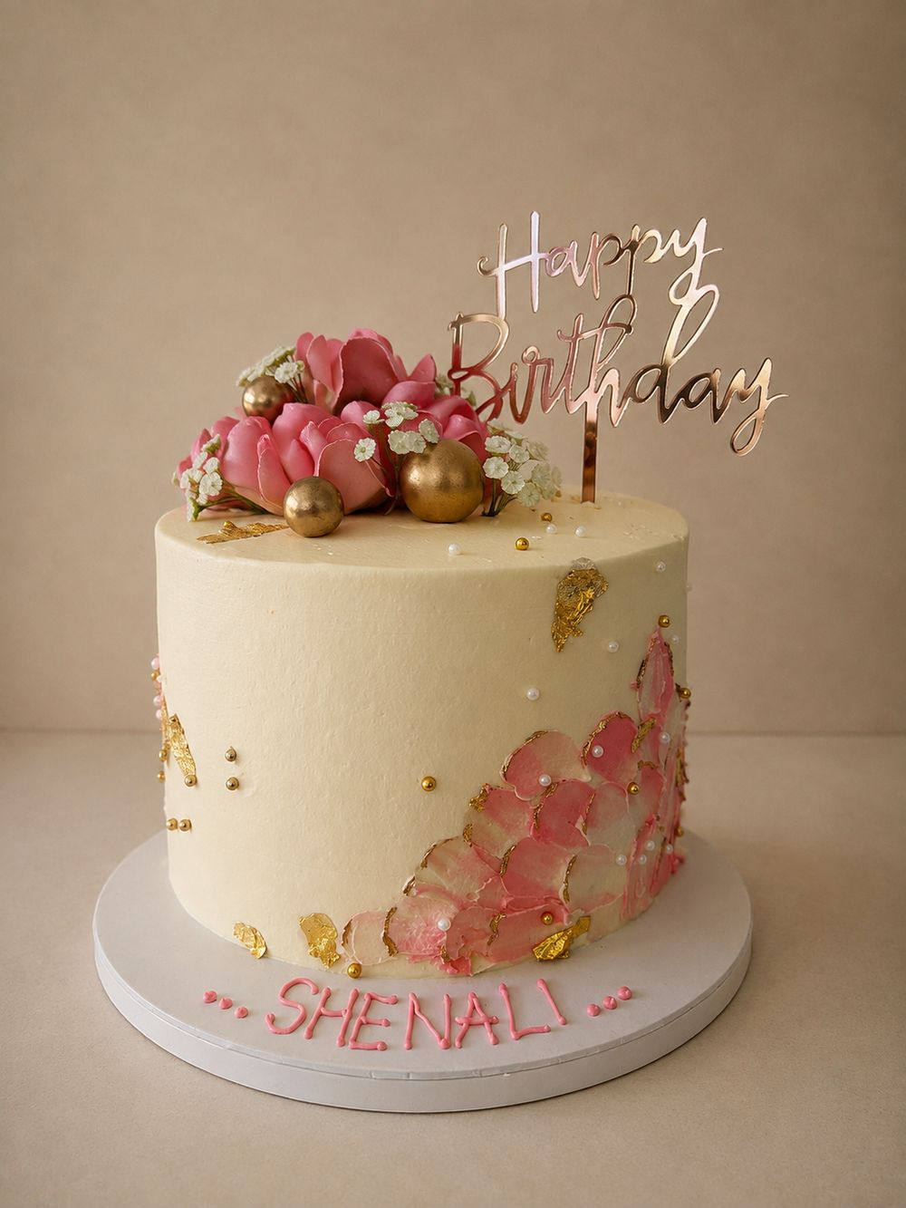 Cream birthday cake with pink peonies and gold leaf