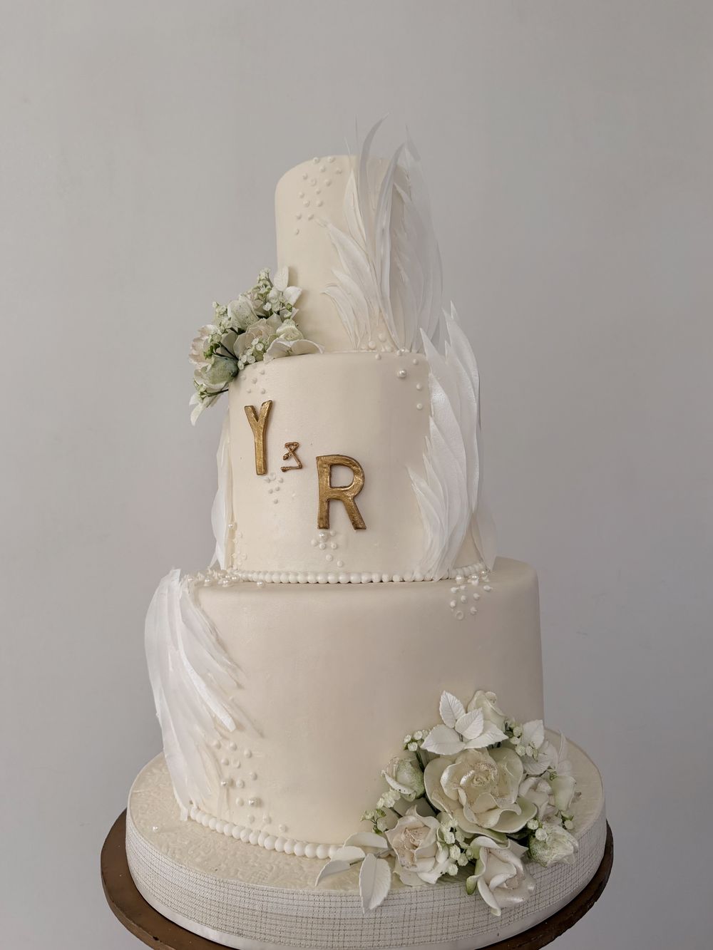 Wedding cake with gold monogram and feathers