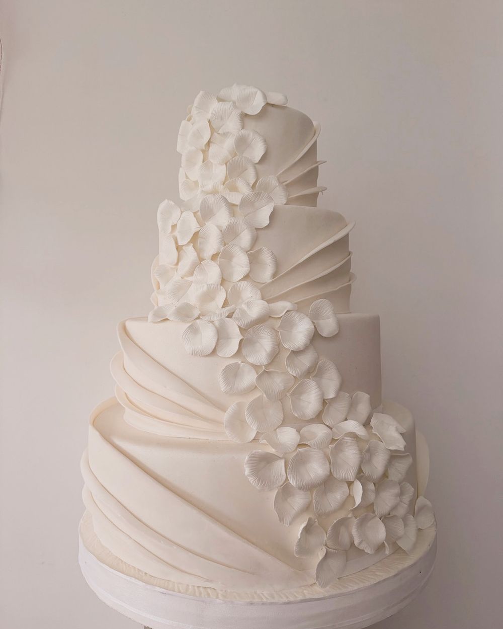 Draped wedding cake with sugar petals